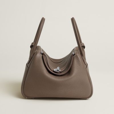 Lindy 26 in Etoupe Clemence, with handles and a shoulder strap.