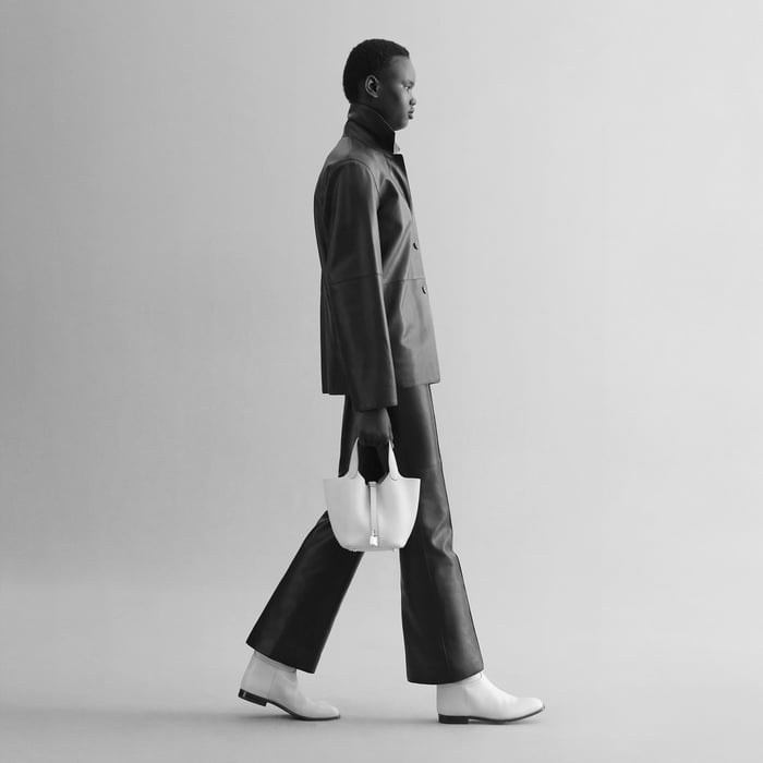 Black-and-white photo of a model carrying a Picotin Lock 18 by its handles